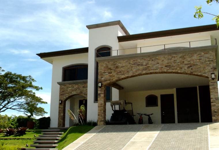 Esta vivienda tiene una extensión de 400 metros cuadrados, dos plantas, y un valor aproximado de 800 mil dólares.   En la fachada, el detalle que captura la atención, es la puerta de la entrada, que en este caso, fue la casa la que se tuvo que adaptar a la puerta y no al revés, como usualmente sucede.   La casa tiene muchas espacios integrados, y ventanales que facilitan la ventilación cruzada.