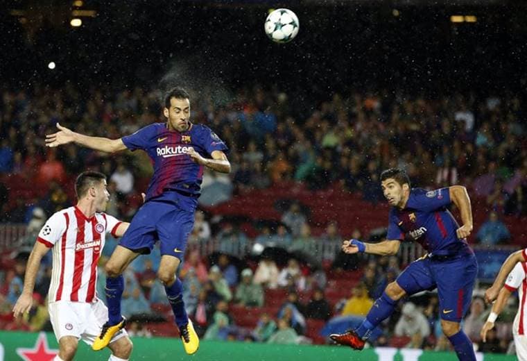 Sergio Busquets y Luis Suárez intentan cabecear un balón ante el Olympiacos |Archivo.
