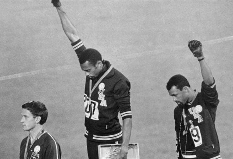 Durante la ceremonia de 200 metros planos, los atletas Tommie Smith y John Carlos elevan sus manos con un puño negro en protesta por el mal trato a los afroamericanos.|AFP