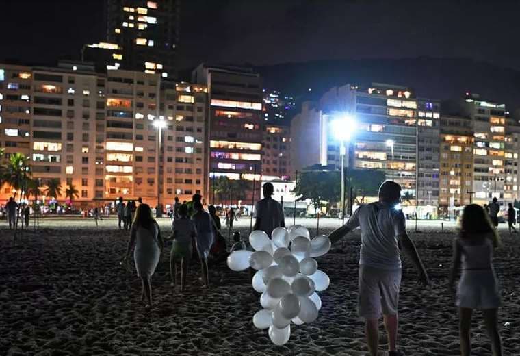 Un puñado de personas celebran el Año Nuevo en la playa de Copacabana, en Rio de Janeiro, 