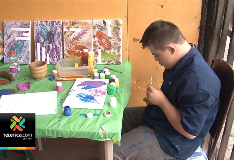 Joven de 15 años con síndrome de Down, autismo y parálisis cerebral pinta cuadros y los vende