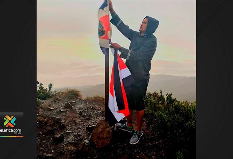 Joven cambia bandera dañada por una nueva en el Cerro de la Muerte
